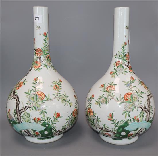 A pair of Chinese enamelled porcelain bottle vases, each painted with Birds of Paradise amid blossoming branches and rockwork, height 3